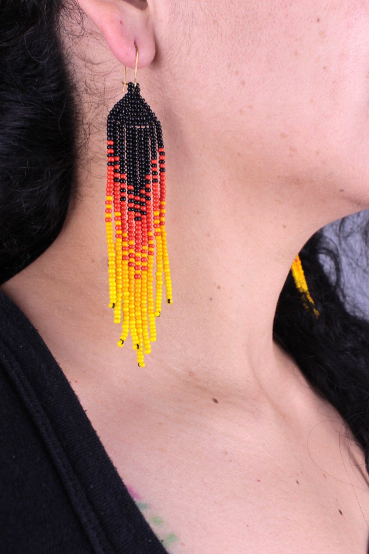 "Nine strands" earrings, approx. 10.5 cm x 2.5 cm, entirely handmade from colored beads (black, red, orange, and yellow)